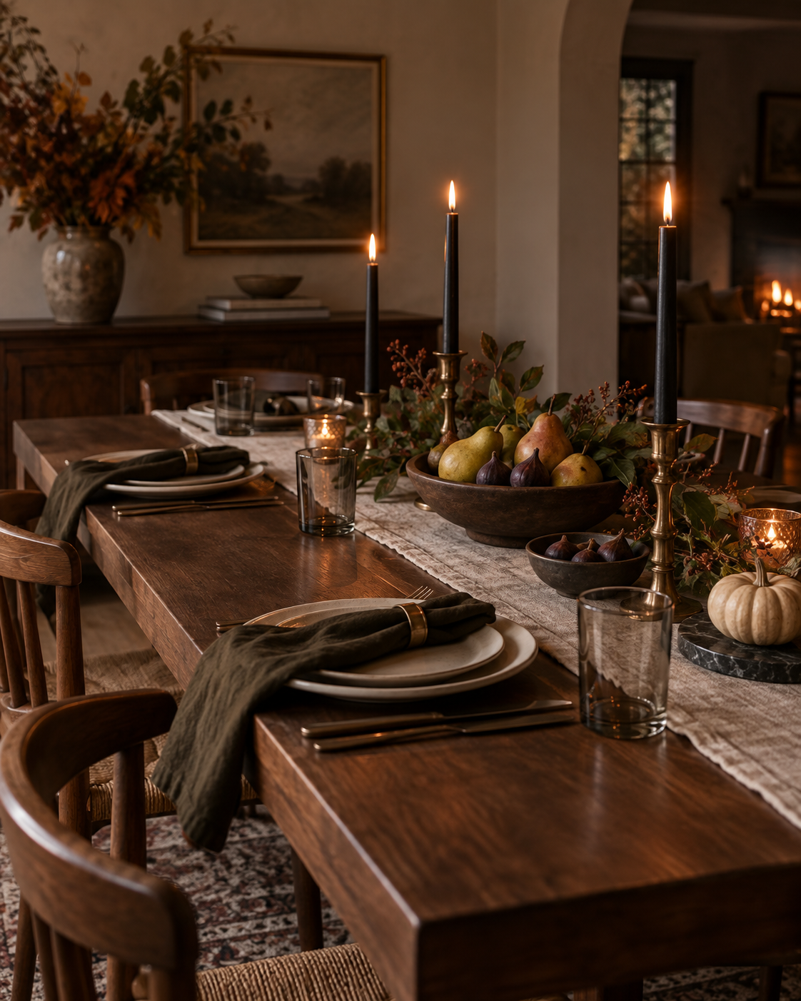 Elegant fall dining table with pears, figs, dark taper candles, linen, and one small pumpkin