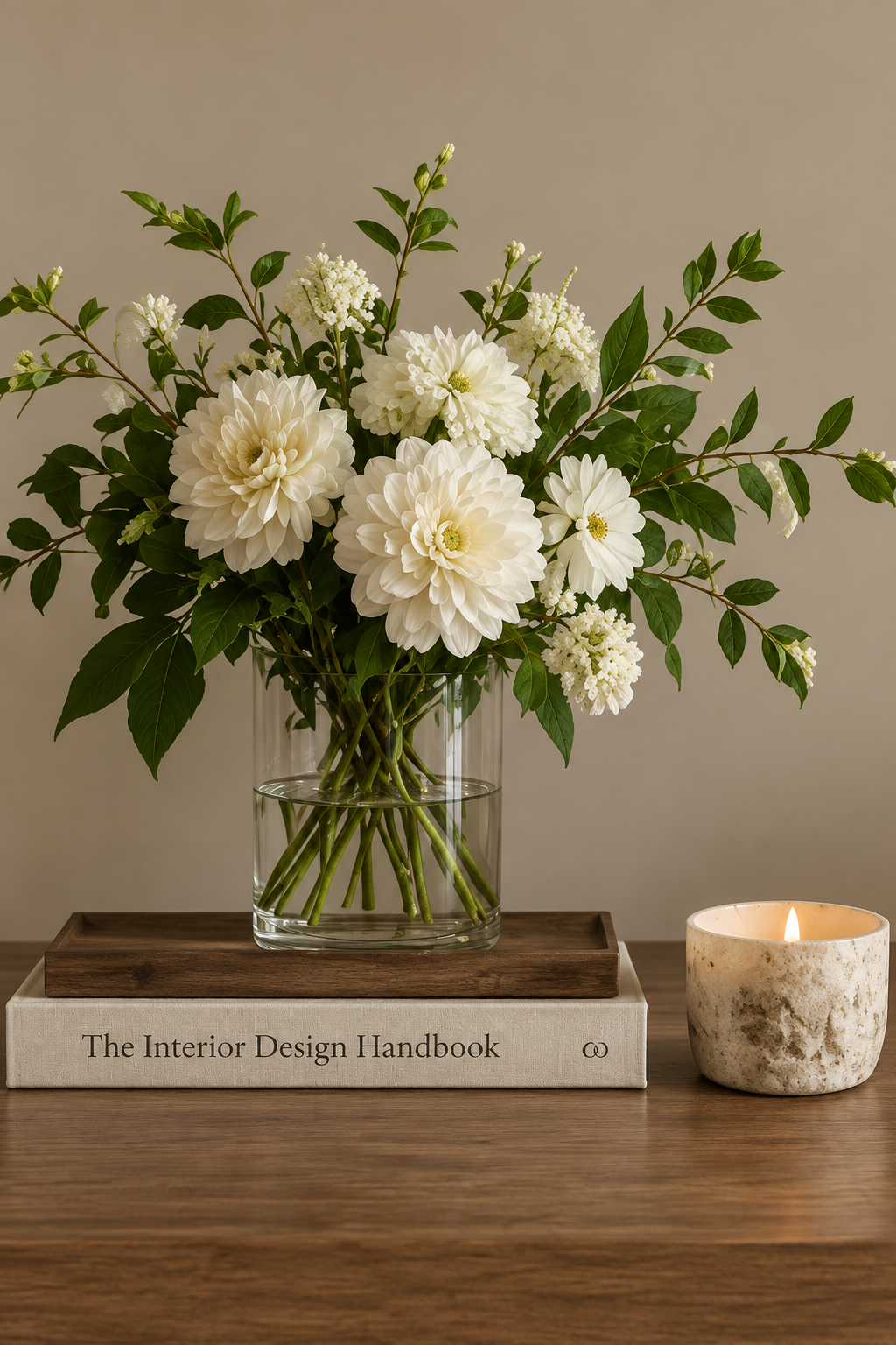 White flowers and leafy branches in a clear glass vase